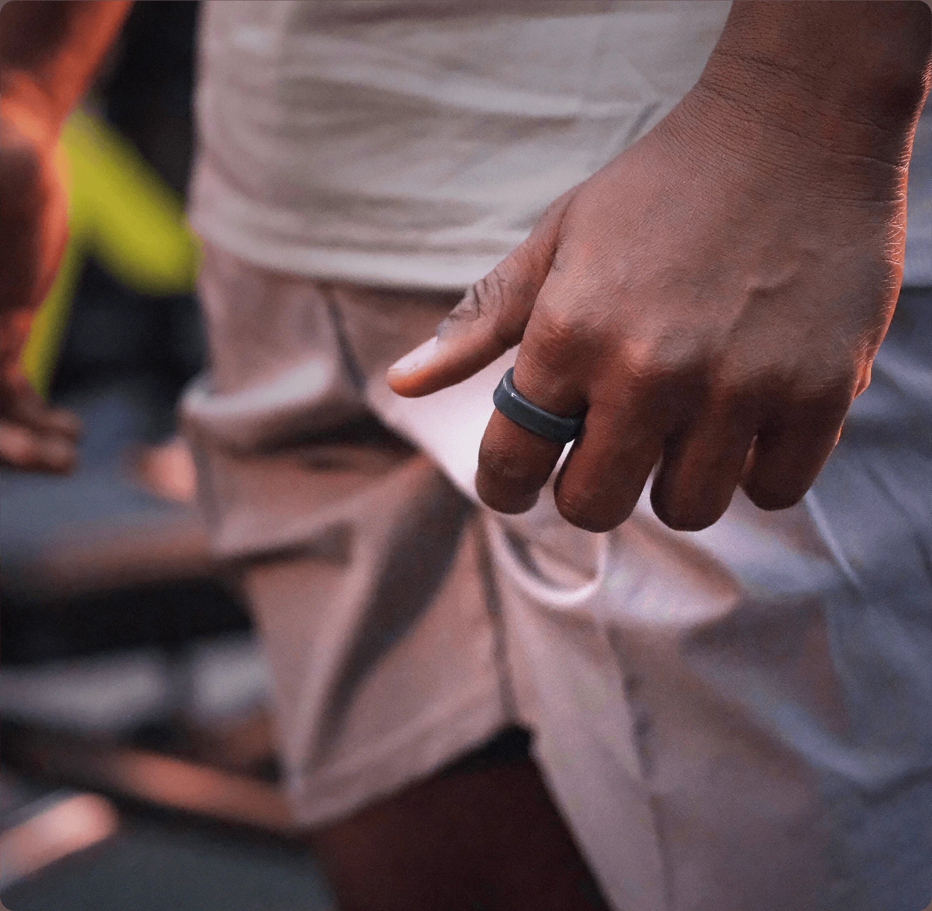 Dark gray smart ring on finger, sleek design, health tracker wearable