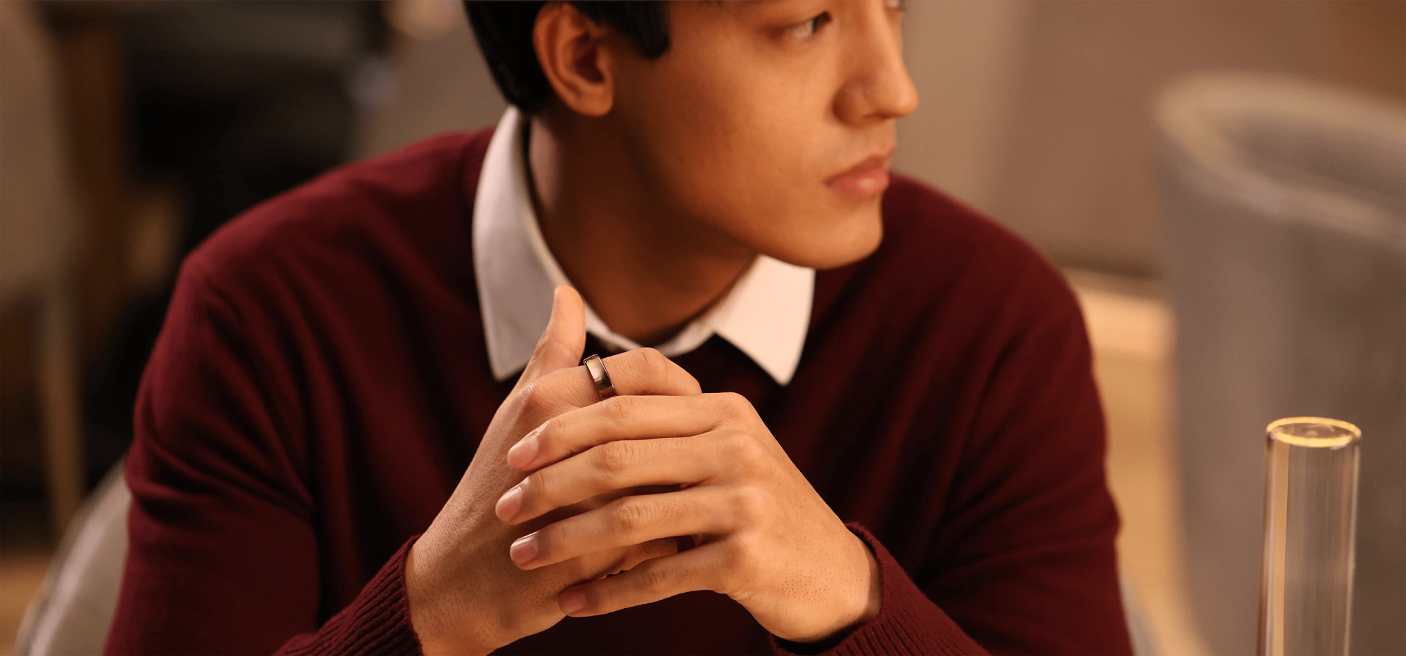 Man wearing smart ring, demonstrating its sleek design and functionality. Focus on the ring's material.
